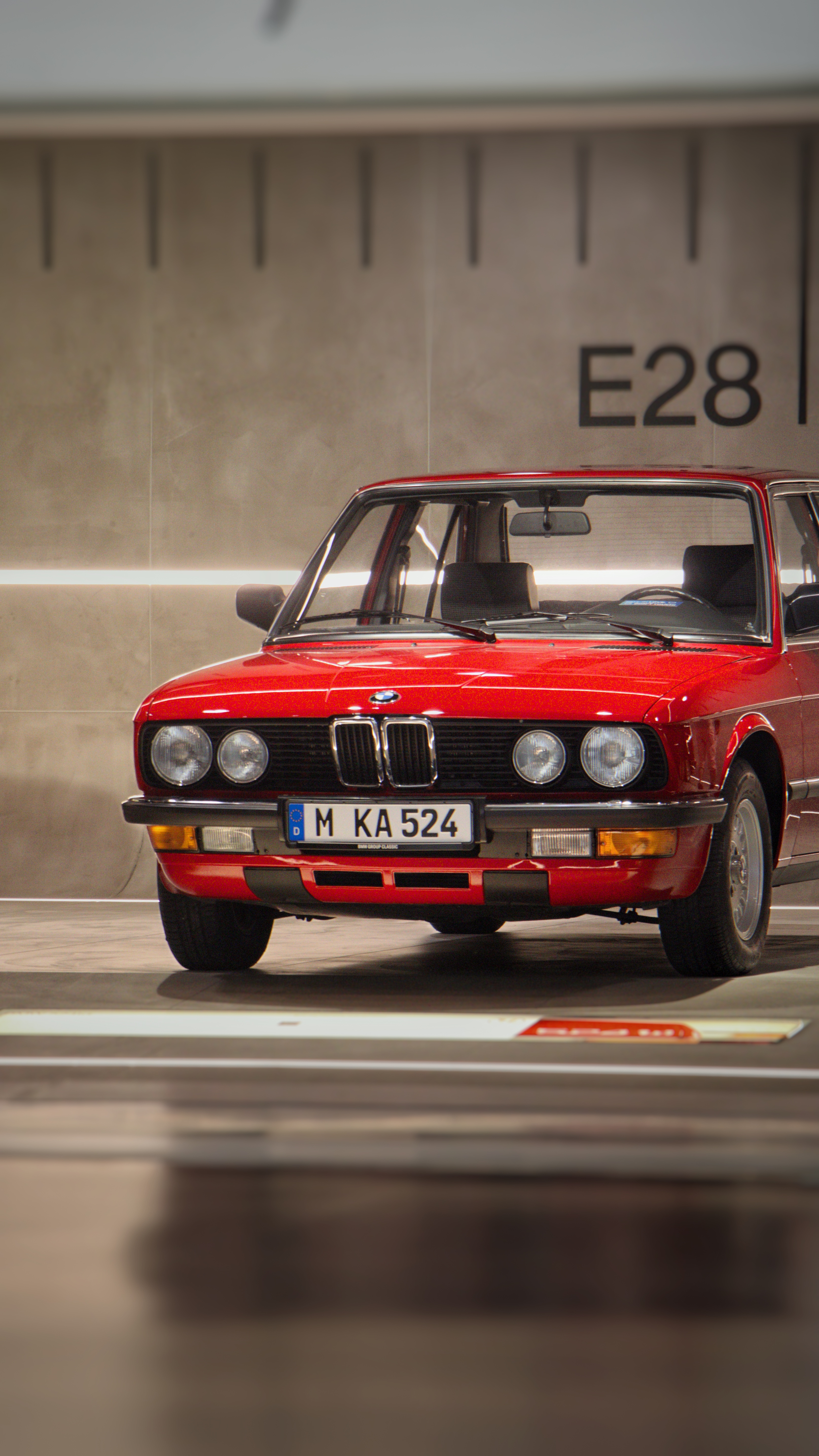 A classic red BMW E28 on display